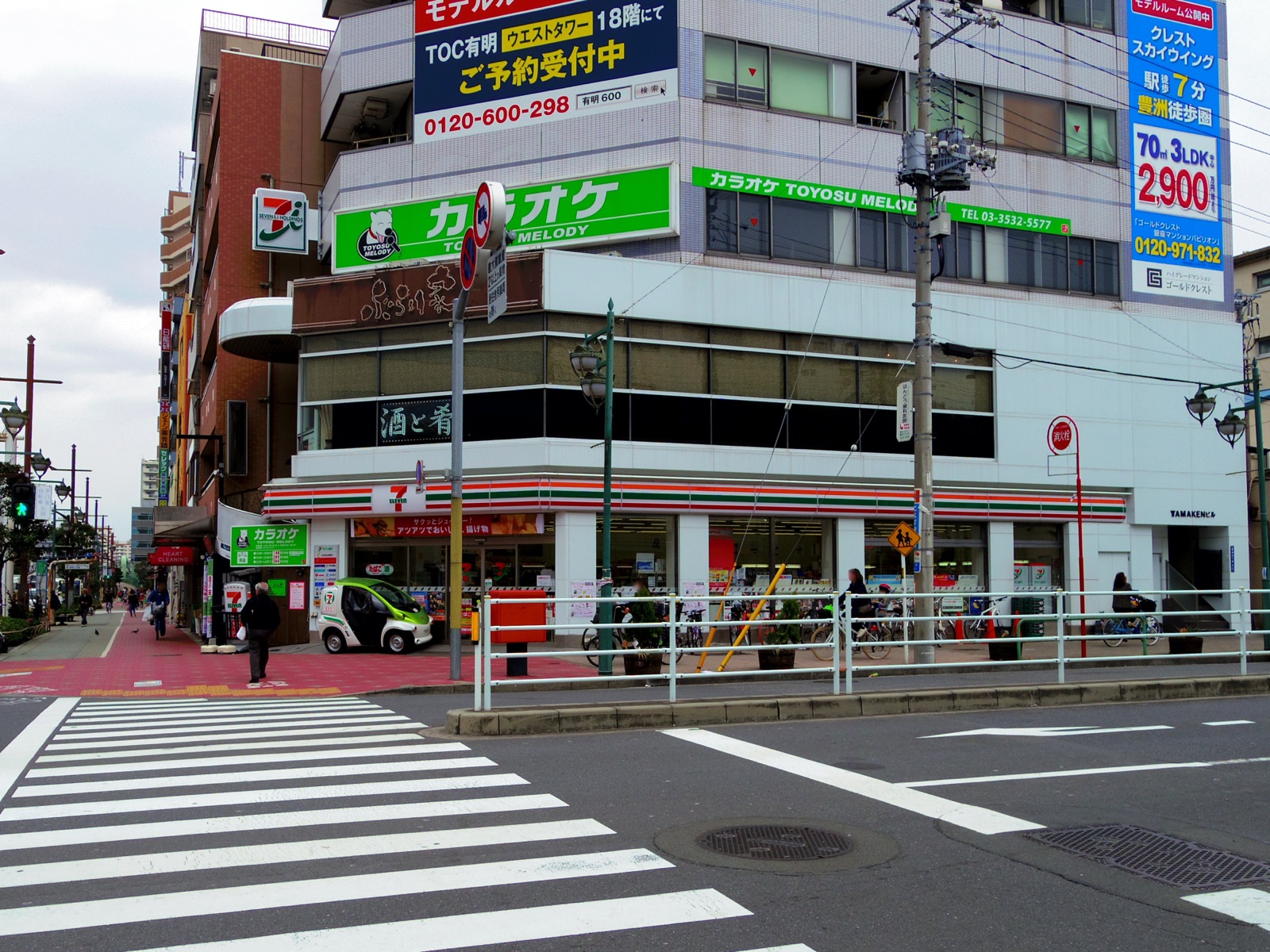 Exterior of a 7-Eleven store in Toyosu, Tokyo, with red green and orange striped signage
