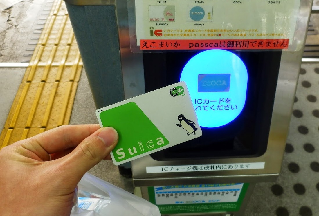 A Suica IC card being tapped on a train station gate reader